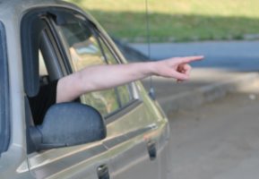 водитель показывает поворот налево рукой